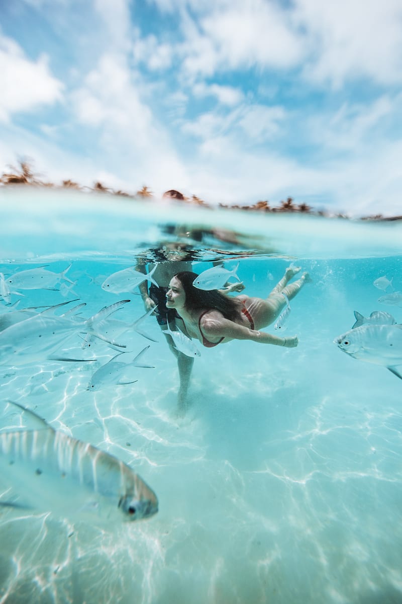A couple swims in the ocean in the Maldives.